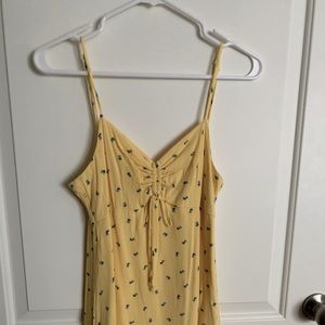 Super pretty yellow soft mini dress with blue flowers and a cinch detail!